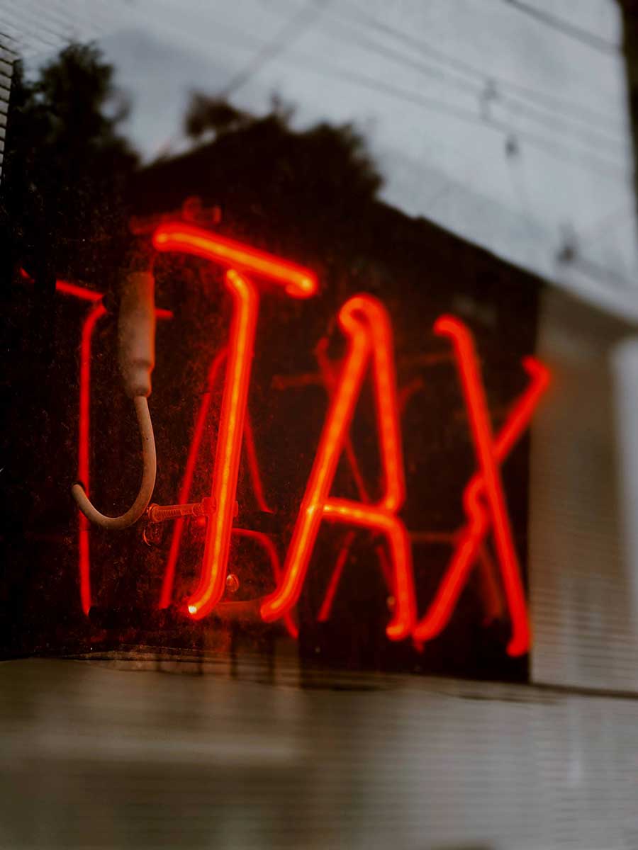 This is an image of the word tax illuminated in a window
