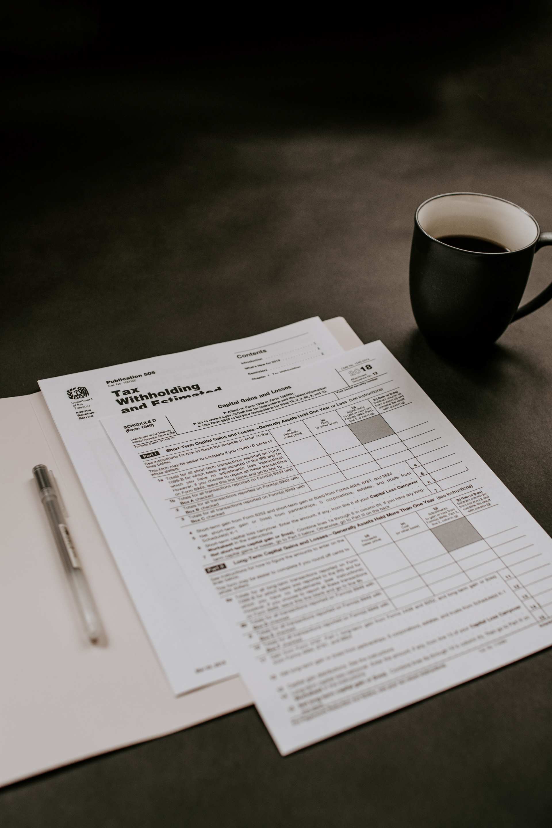This is an image of paperwork and a coffee on a black table