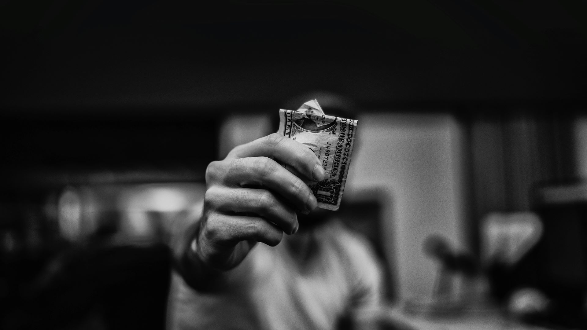 This is an image of a man holding money in front of his face